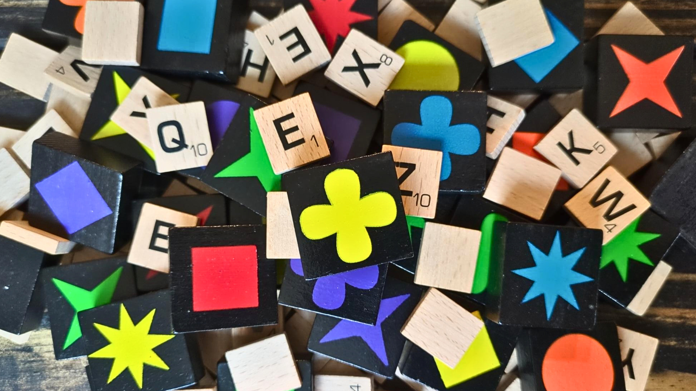 Pile of Qwirkle and Scrabble game tiles