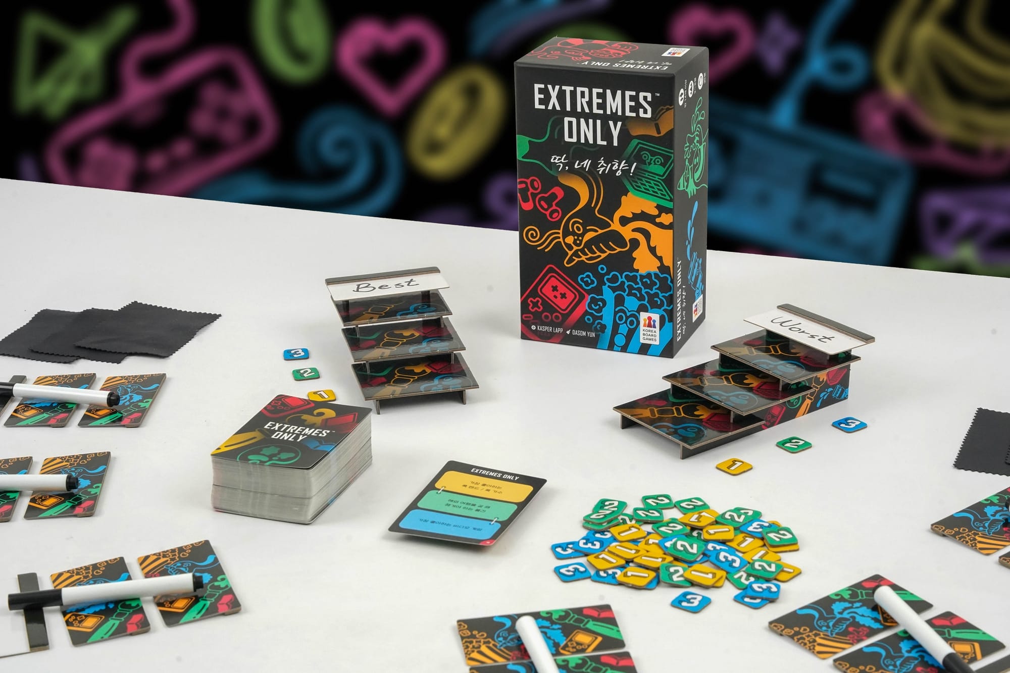 The Extremes Only game box surrounded by cards, scoring tokens, pens, and whiteboards