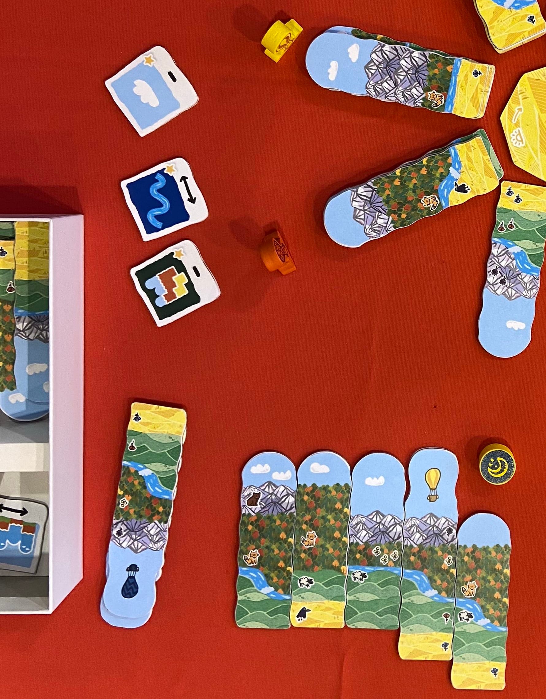 Five tiles are next to one another in a player's landscape, with a giant forest area across all five tiles and separate rivers and mountains