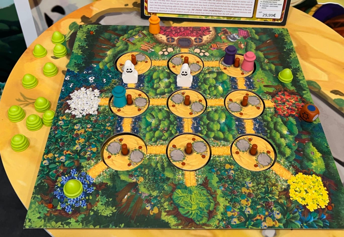 A game board shows player figures and ghosts on a pathway in a forest that contains nine cut-out circles