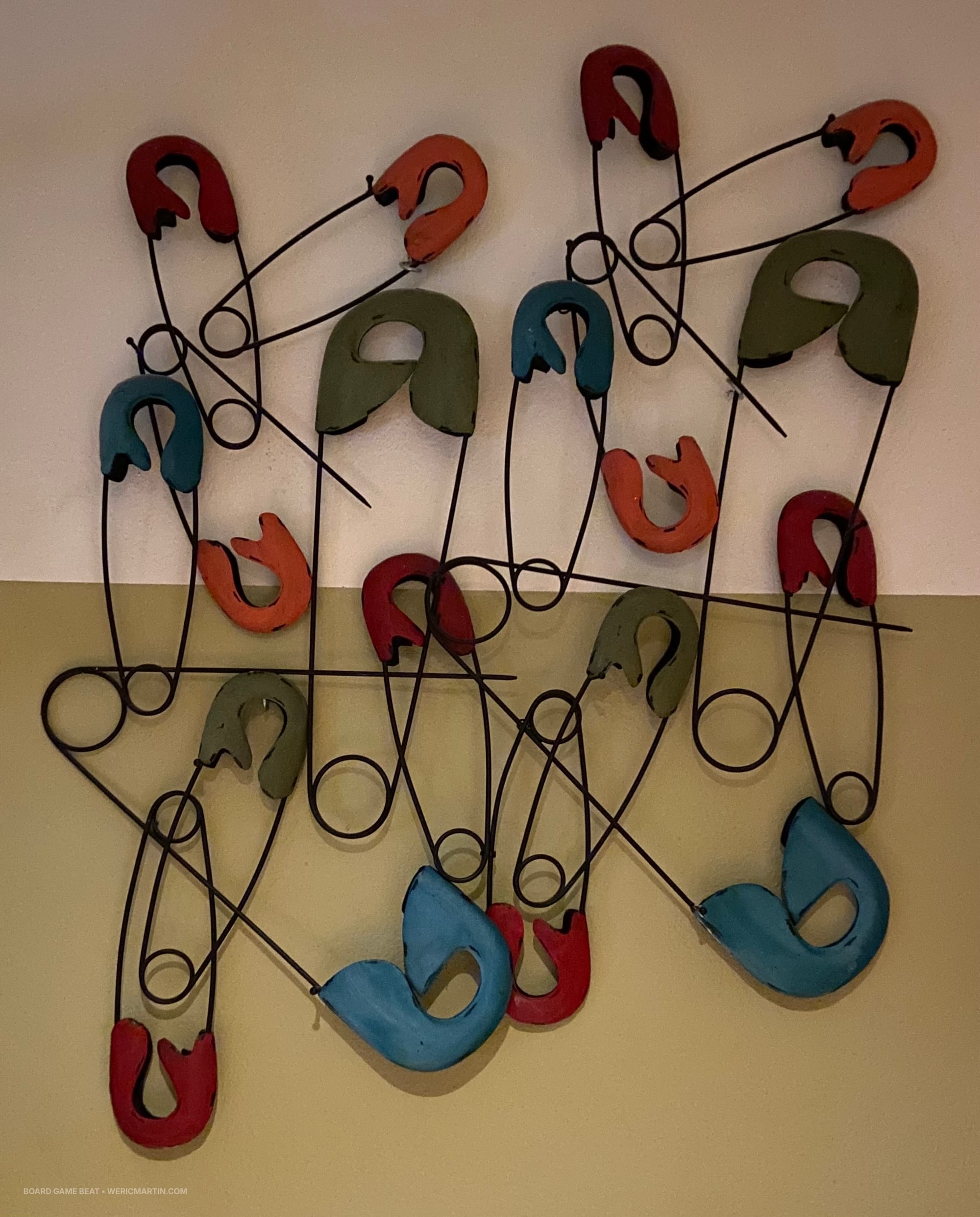 Giant safety pins hang together on a wall