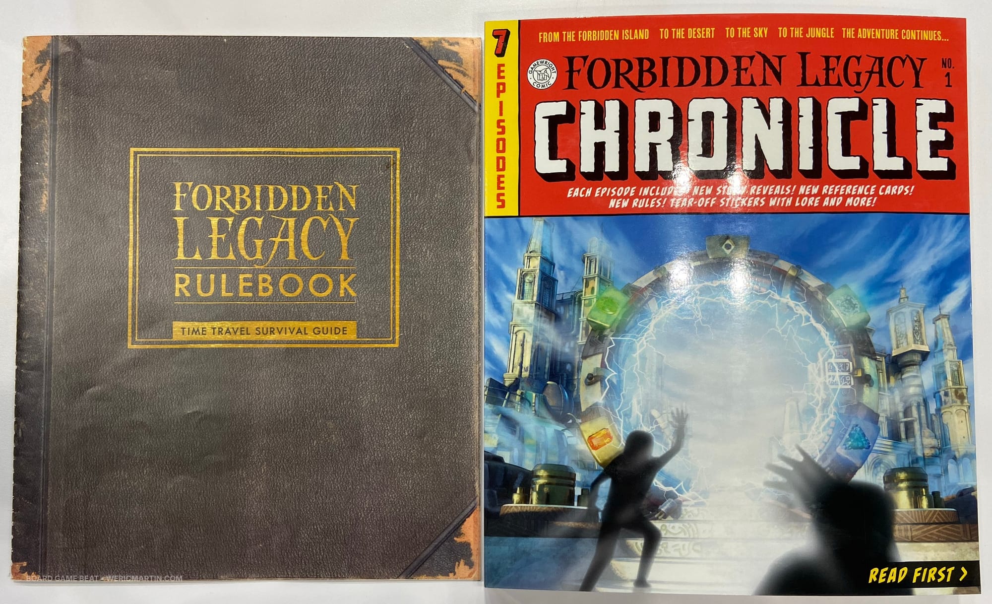 The thin Forbidden Legacy rulebook is next to the Forbidden Legacy picture book with tear-out pages and items