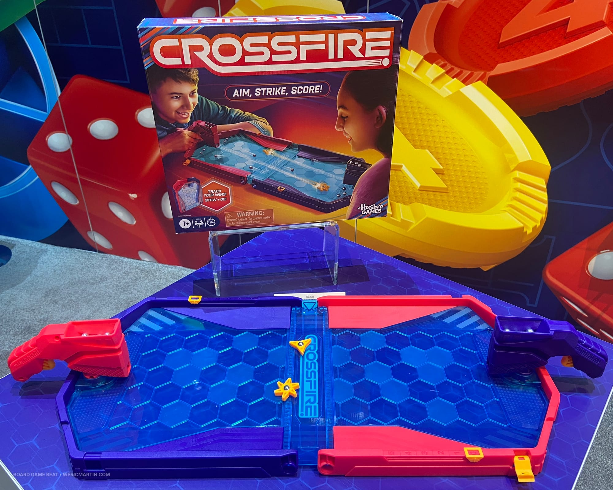The game box for Crossfire is shown, along with the components: a plastic arena with a BB-shooting gun on each end