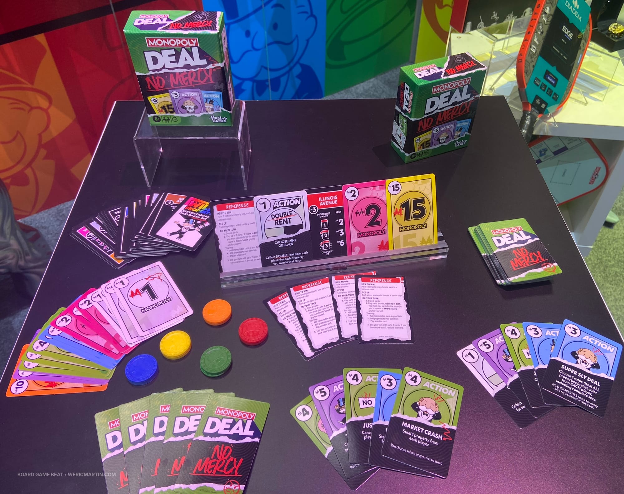 The box of Monopoly Deal: No Mercy, along with cards from the game