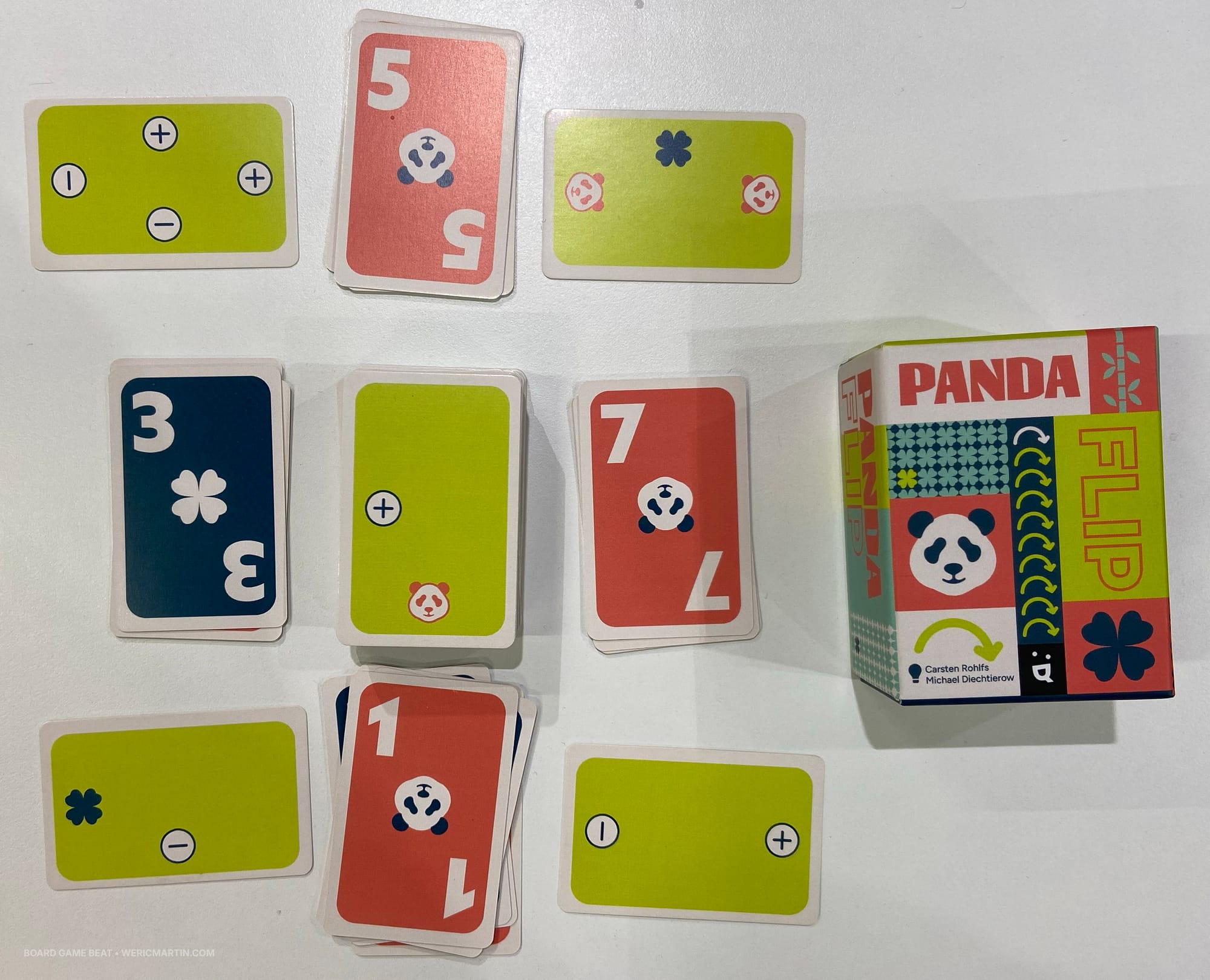 Front cover of the game Panda Flip, along with face-up and face-down cards, with the former showing either a clover or panda and a value of 1-7