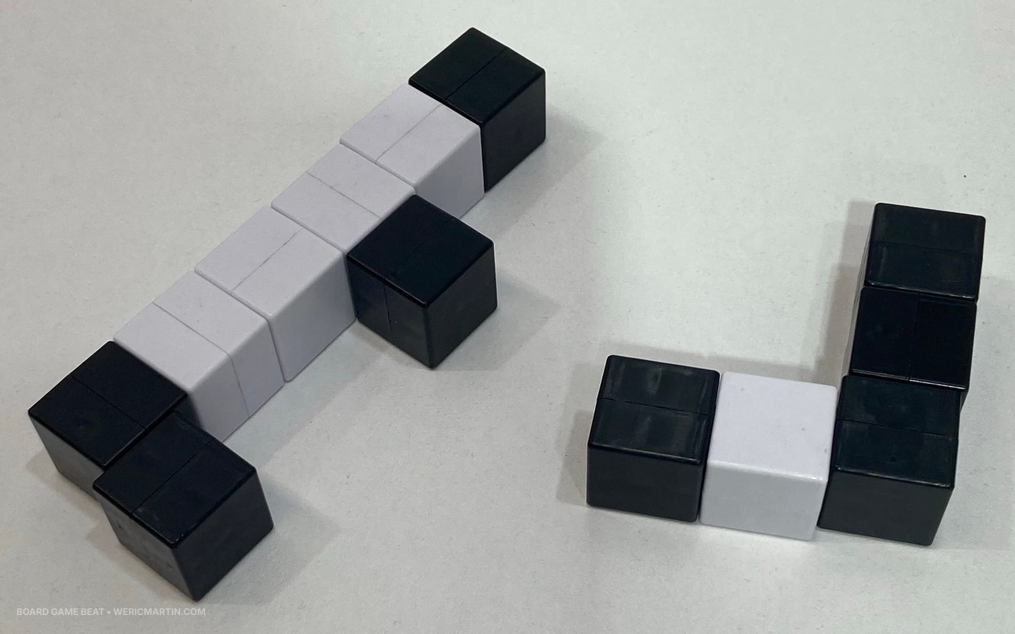 Black and white cubes are stuck together with magnets into two chunks of pieces