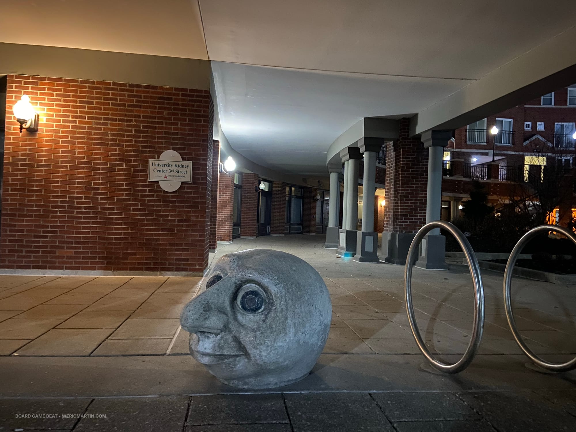 A cartoonist concrete head about two feet tall is attached to the street near the University Kidney Center in Louisville, KY